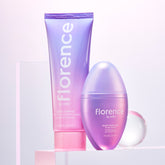 Florence by Mills skincare set with cleansing balm and glaze drops in purple ombre packaging. Millie Bobby Brown wears red knitted crop top and trousers
